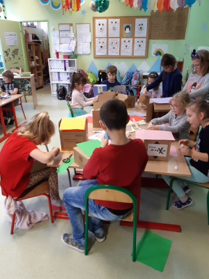 uczniowie klasa lekcyjna stoliki przybory