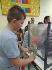 dzieci chłopiec maluje na folii przeźroczystej